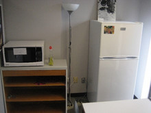 Photo d’un local est réservé au personnel du Département présentant une table, un four micro-onde et un réfrigérateur